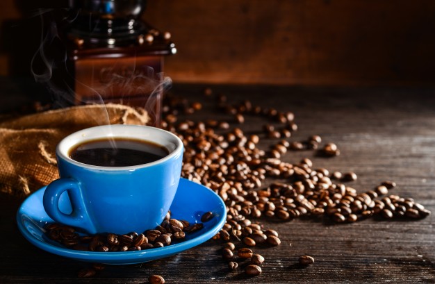cup of coffee with coffee beans and grinder background 1112 430
